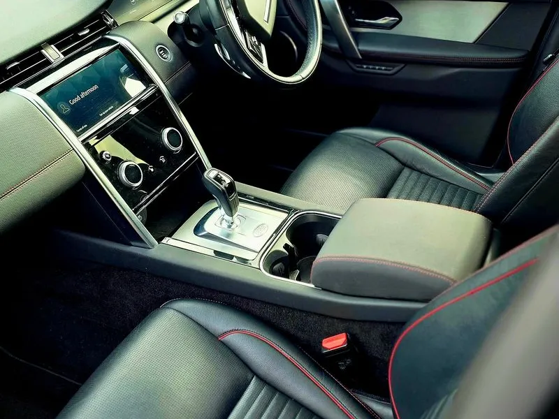 Black leather interior cabin with red stitching and clean dashboard