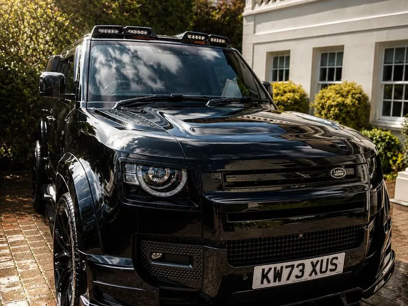 Black Land Rover Defender front view with roof lights