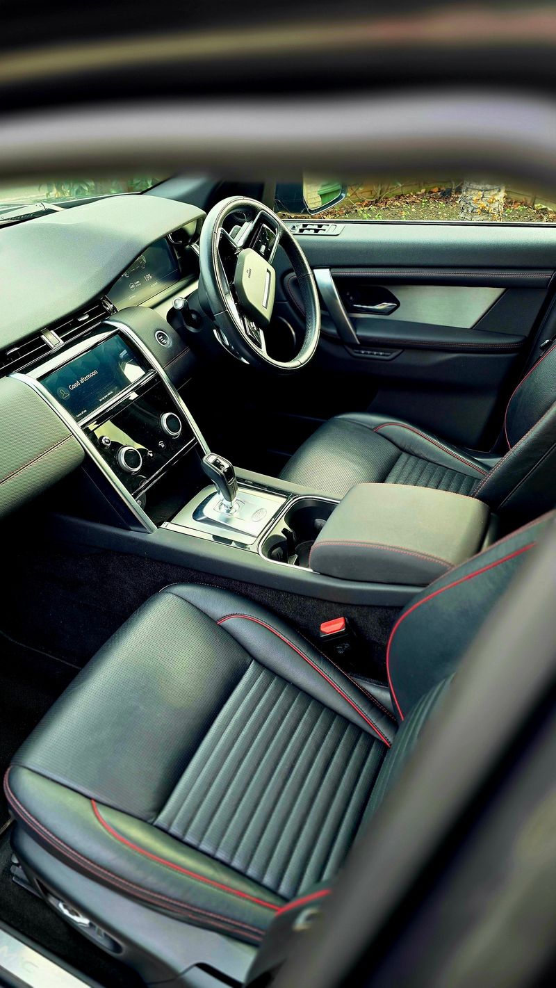 Black leather interior cabin with red stitching and clean dashboard
