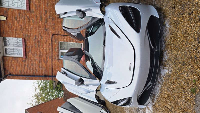 Silver McLaren with dihedral doors open, front view
