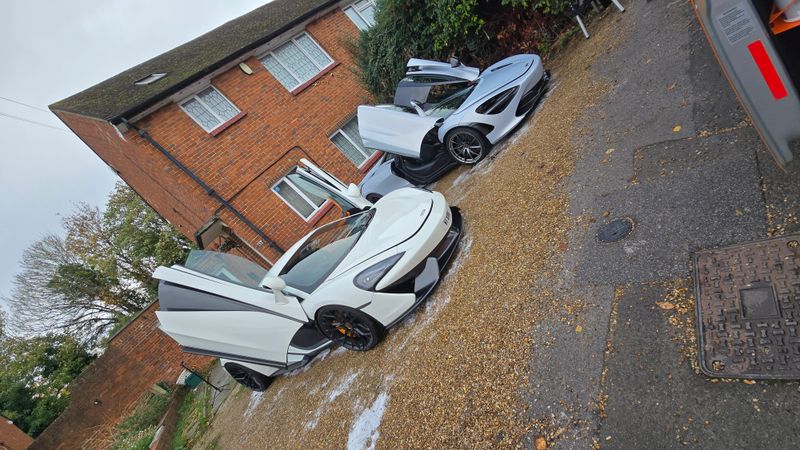 White and silver McLarens parked with doors open