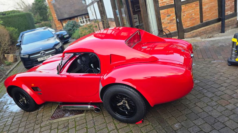 Bright red AC Cobra exterior rear quarter view